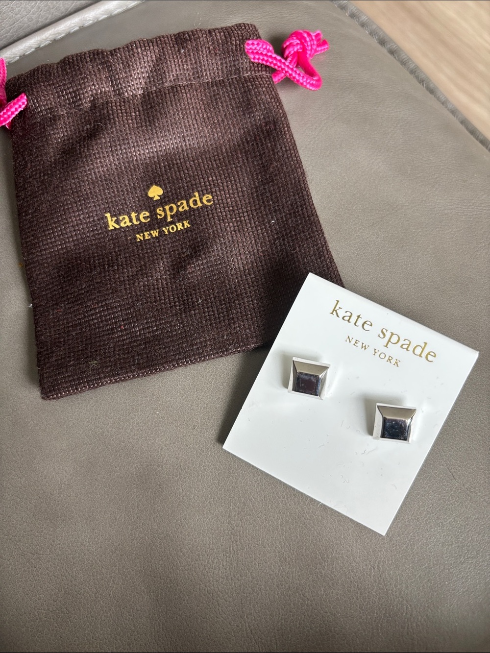 kate spade silver square stud earrings with brown pouch and pink drawstring